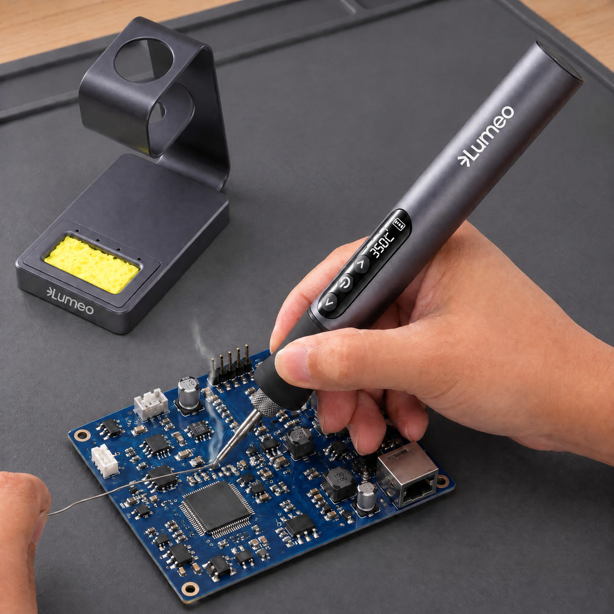 Hand using the Lumeo QuickFix cordless soldering iron on a circuit board at 350C