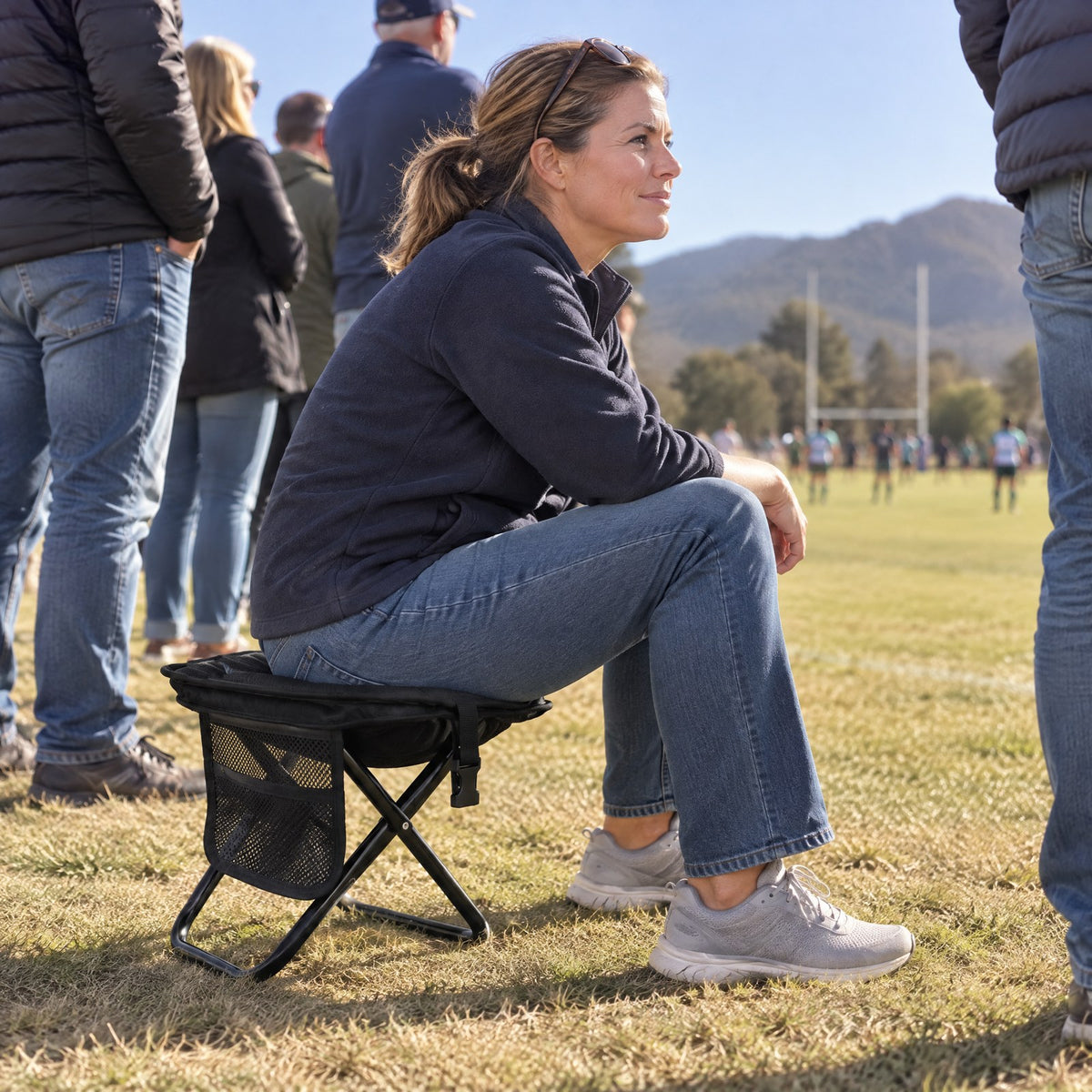 Sitting on the Lumeo Sling Stool at a rugby touchline
